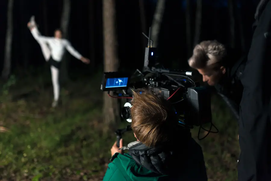 Dancer in a forest at night, crew at the camera