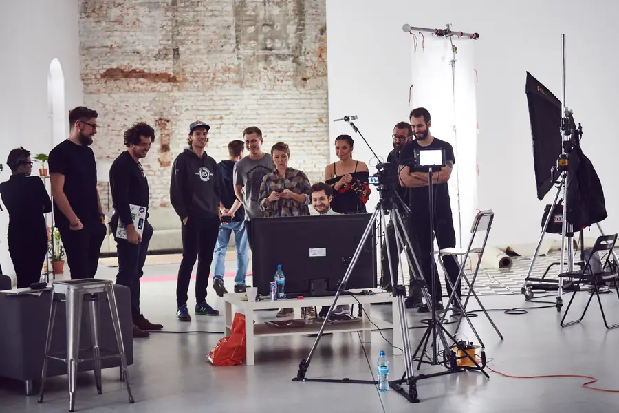 Crew and athletes in a brick-walled studio
